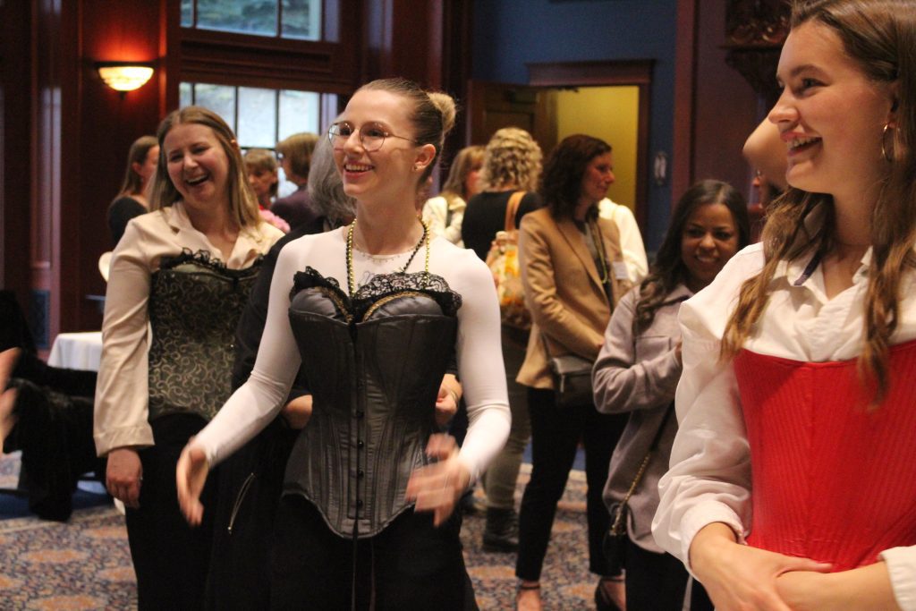 Some event attendees having fun trying on corsets