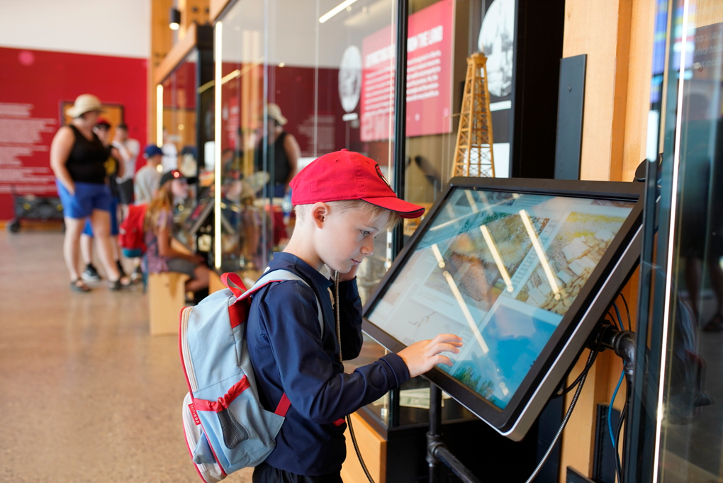 A young boy interacting with StorySeeker at Heritage Park's Innovation Crossing exhibit