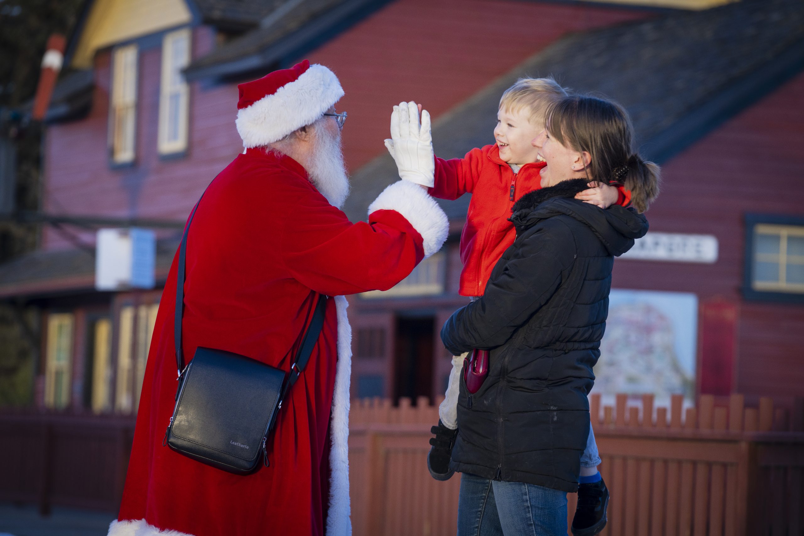 Santa high-fiving a young child