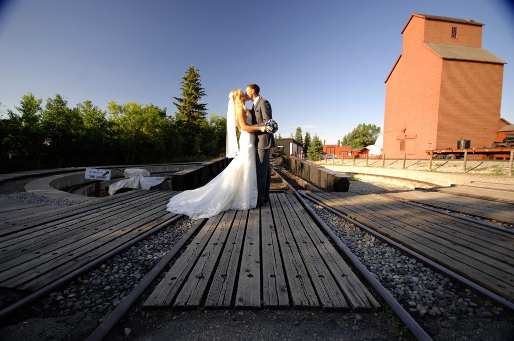 A couple kissing on train tracks at Heritage Park