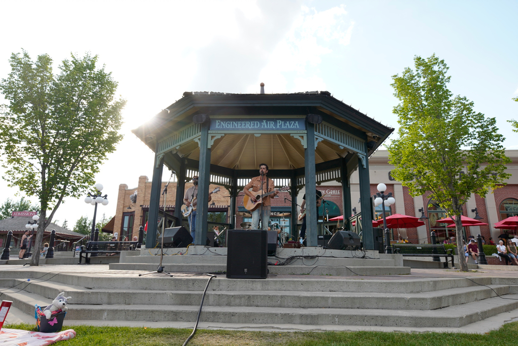 A man playing guitar at Heritage Park's Engineered Air Bandstand, located in Heritage Towne Square