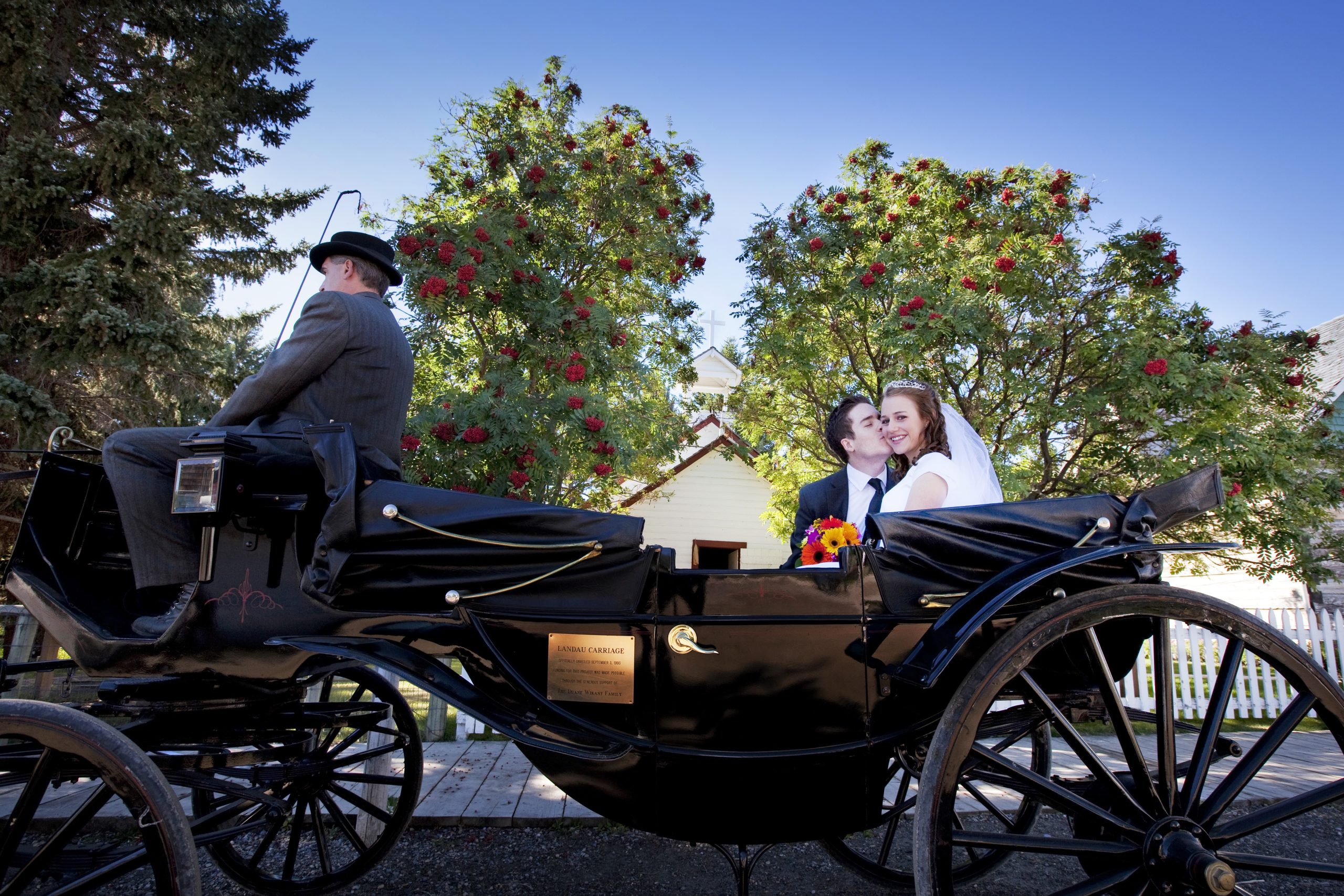 A couple kissing in an old-fashioned horse-drawn carriage