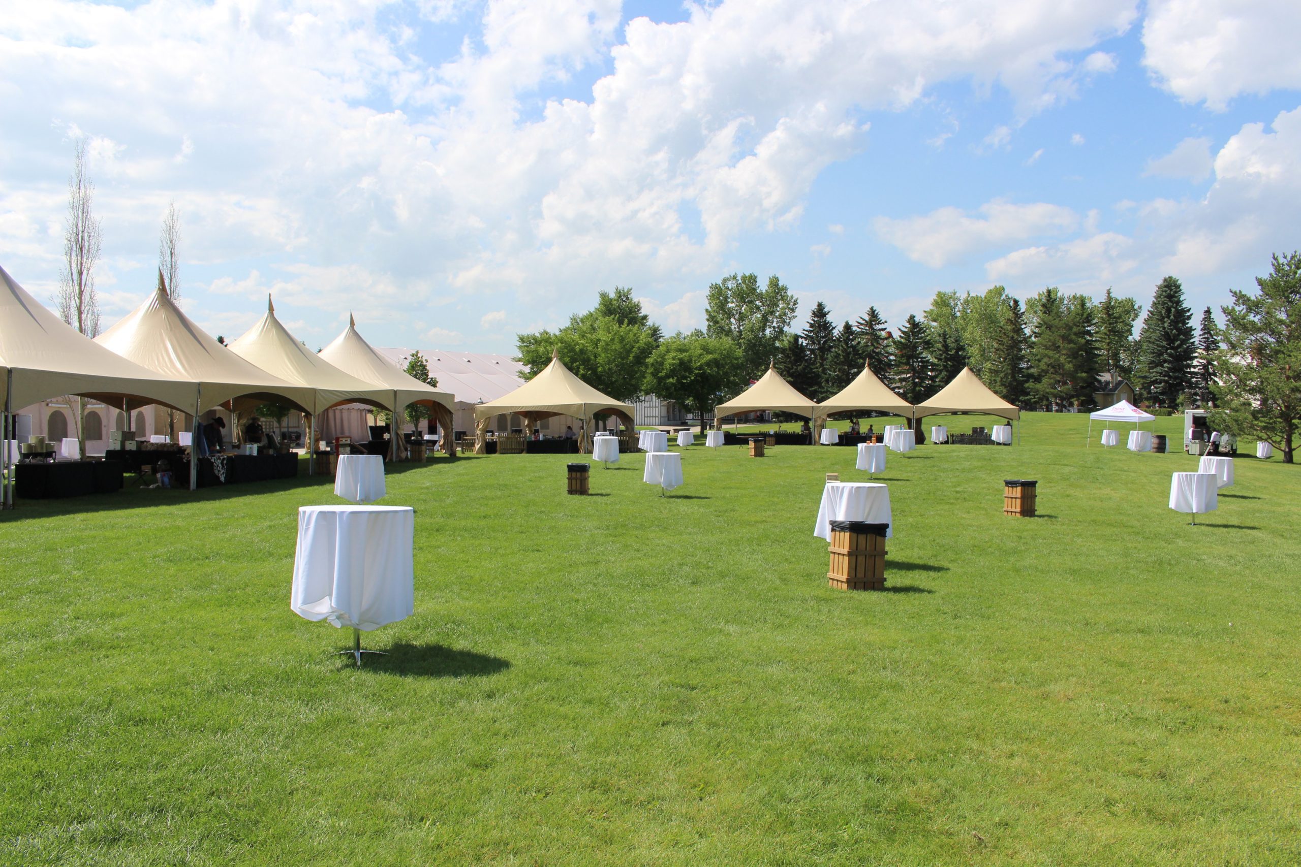 An outdoor event set up with tents and tables on the greenspace in Heritage Park