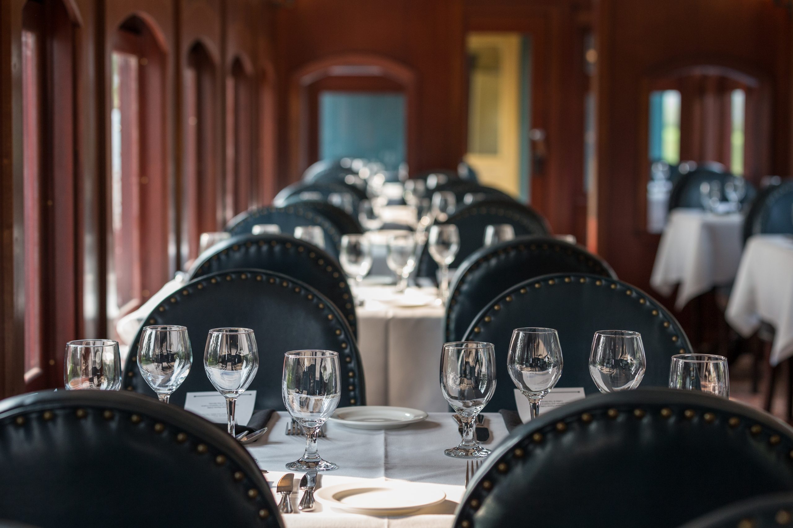 A set table with wine glasses on it in the River Forth Dining Car at Heritage Park