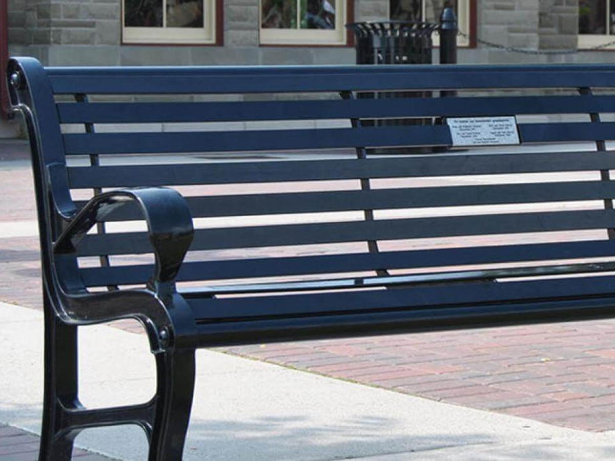 A memory bench at Heritage Park features a dedication to a loved one