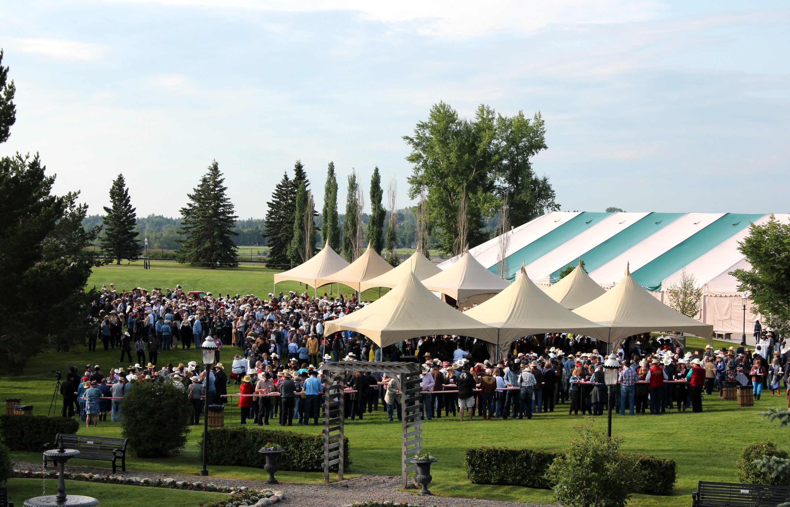 A large gathering of people at a Stampede party in the Chautauqua Tents at Heritage Park