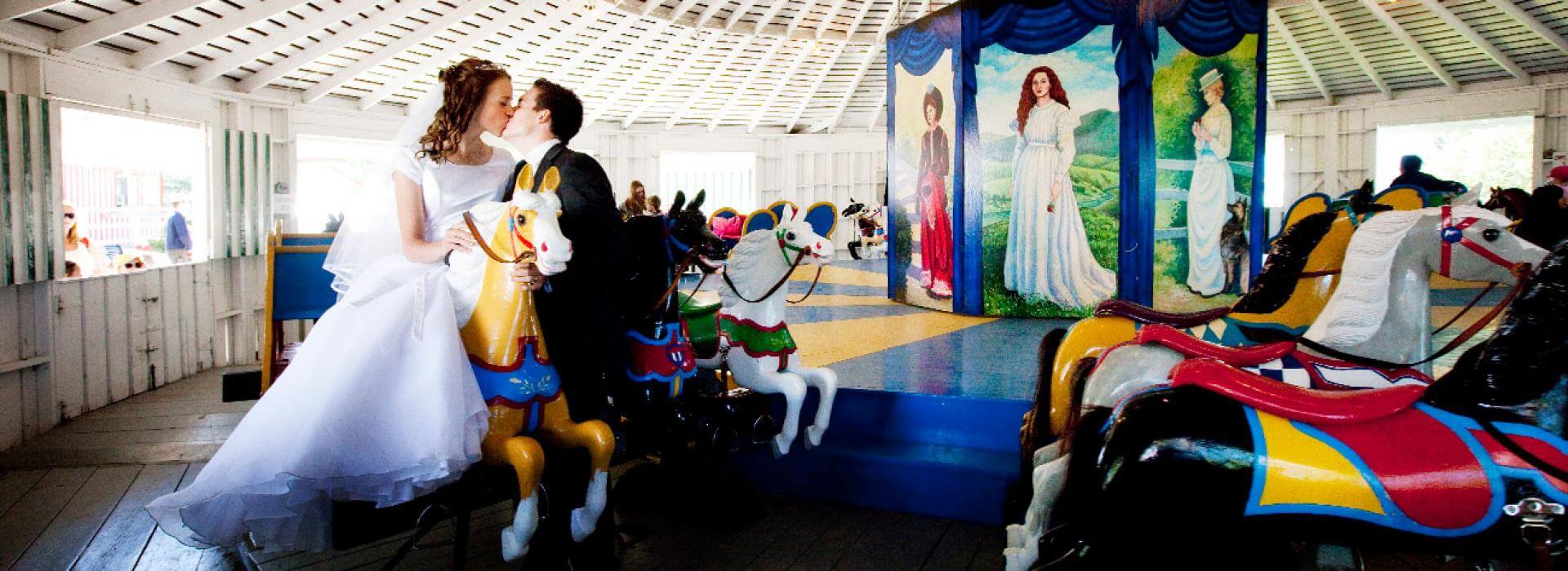 couple sitting on a hose in the carousel just married