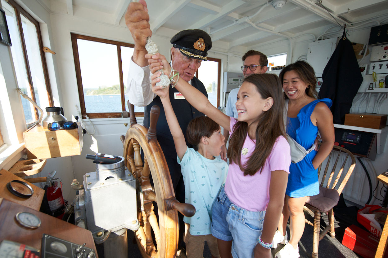A family blows the horn of the S.S. Moyie at Heritage Park