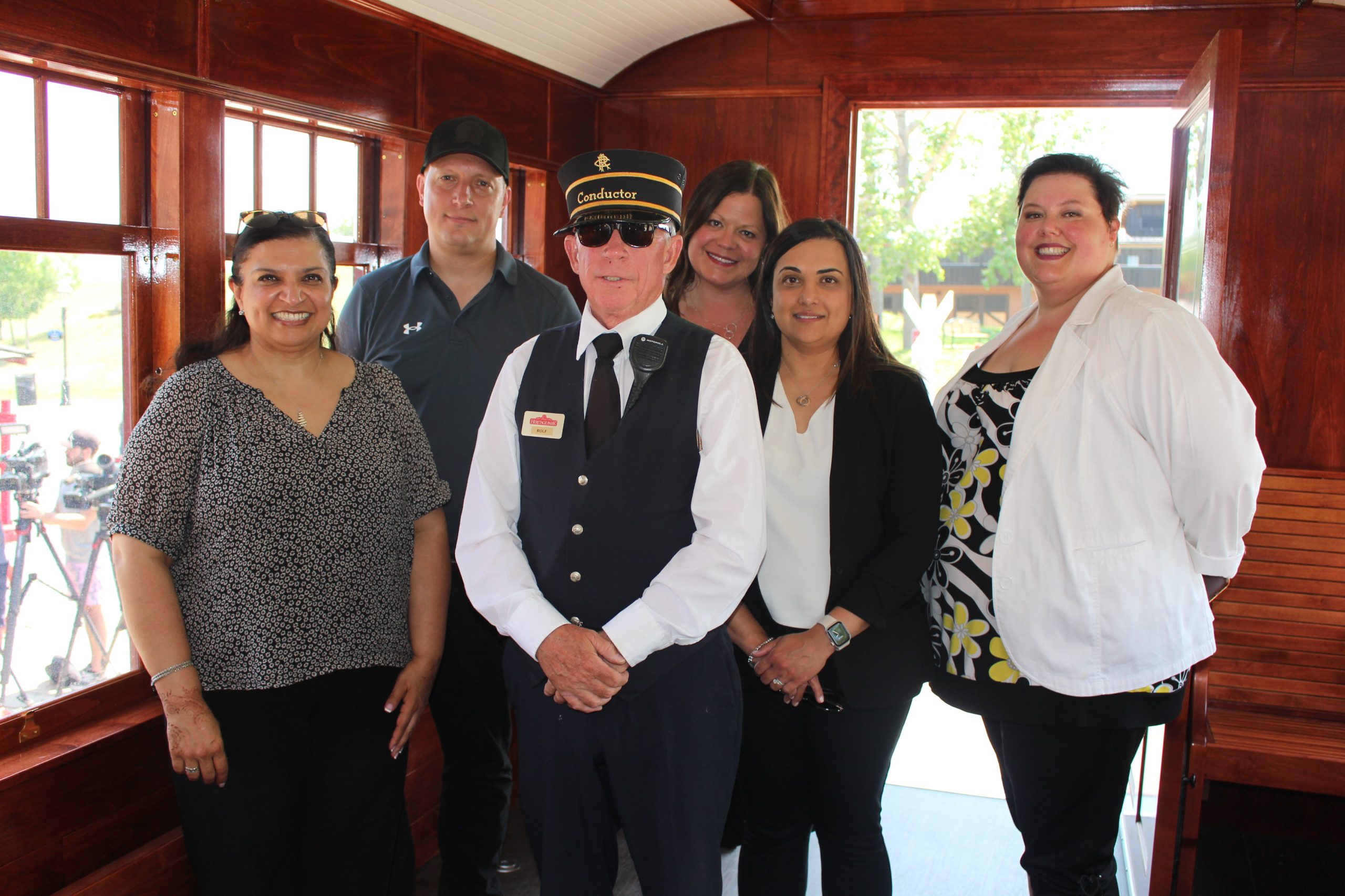 CPKC Team posing with Heritage Park's conductor on the new fully-accessible railcar, The Nightingale.