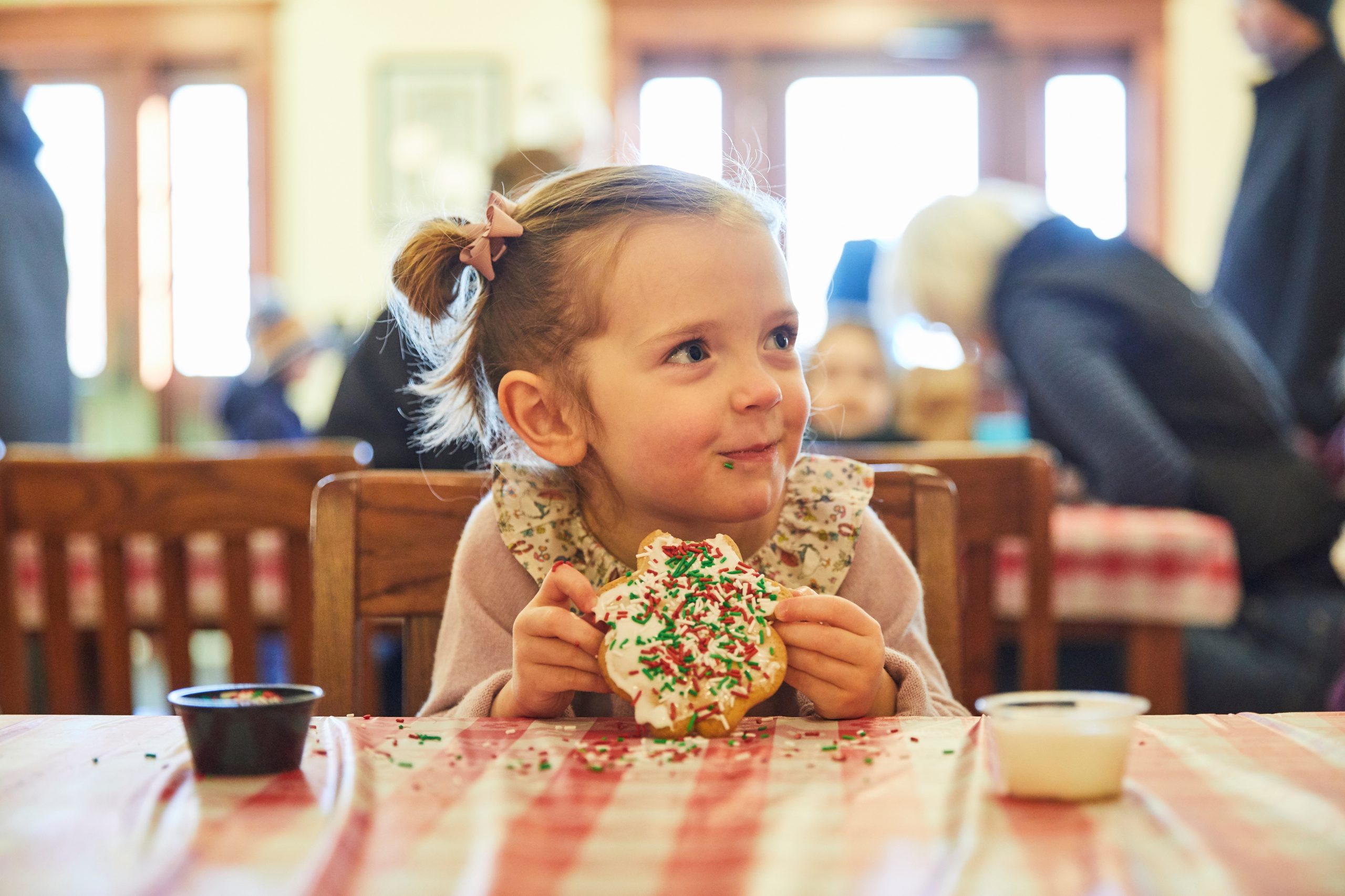 A Child Eats a Cookie at a Children's Christmas Party at Heritage Park during Once Upon A Christmas Holiday Event